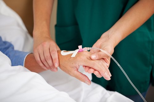 A doctor checking the pulse of a patient on an infusion