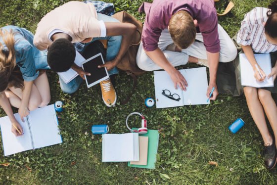 Students clustered together while studying outdoors.